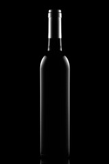 Bottle of dry red wine on a black background