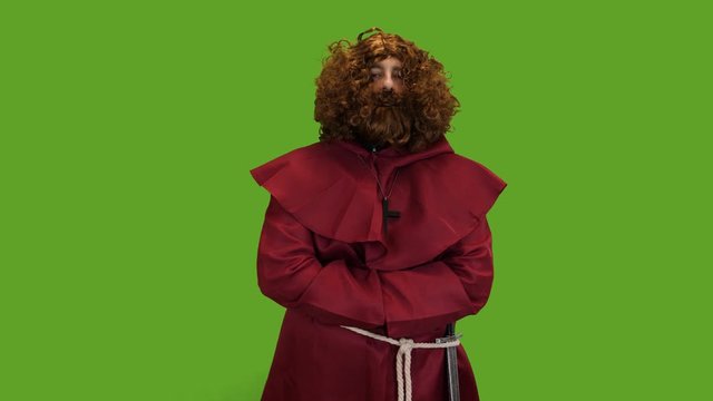 Medieval Bearded priest wearing a sword giving his blessing to the townsfolk green screen