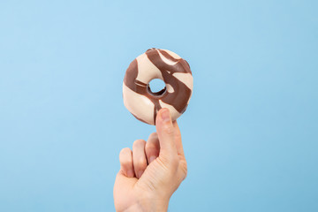 Man hand hold a black and white chocolate donut with copy space