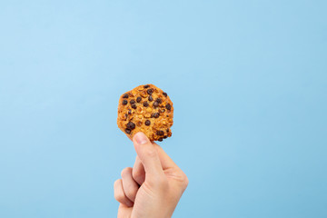 Man hand hold a cookie with toppings with copy space
