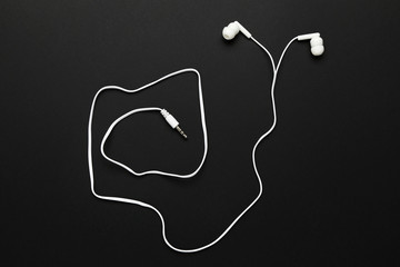 White earphones on black background