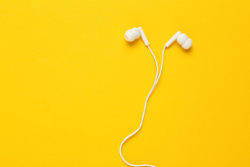 White earphones on yellow background