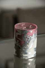 red candle on a concrete base