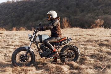 Profile portrait of a motorcyclist equipped with helmet and protective clothing, drives a...