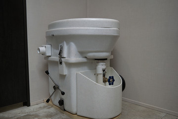 Composting toilet in a RV bathroom that has been adapted to divert urine into the exiting black tank.
