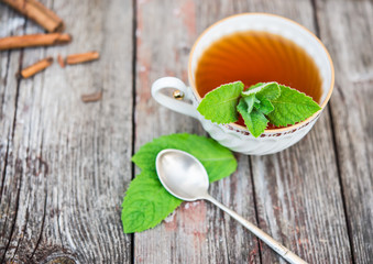 Cups of tea with mint on wooden table