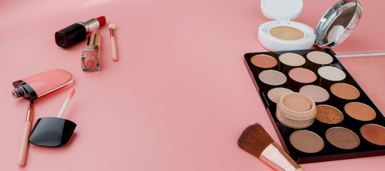 Makeup products on pink background. Top view with copy space
