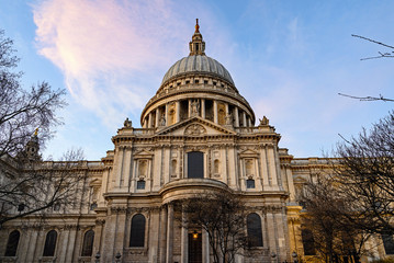 Fototapeta na wymiar St. Paul's Cathedral in London, UK. Evening view of St Pauls taken from the south of the cathedral. View framed by trees. St Paul's famous dome is set against a blue sky with pink clouds. London 2020.