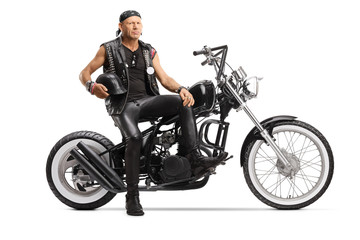 Fototapeta na wymiar Biker holding a helmet and sitting on a custom chopper