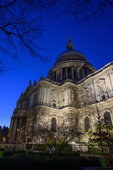 Fototapeta na wymiar St. Paul's Cathedral in London, UK. Evening view of St Paul's taken from the southeast of the cathedral. Illuminated building, dark blue sky and trees
