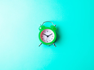 green alarm clock isolated on pastel color background