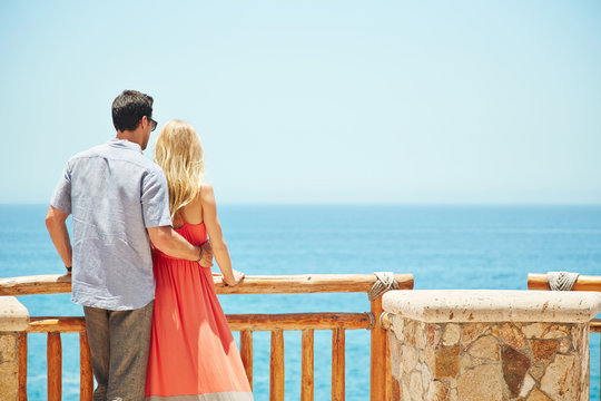 Romantic couple looking at the ocean in Mexico - Powered by Adobe