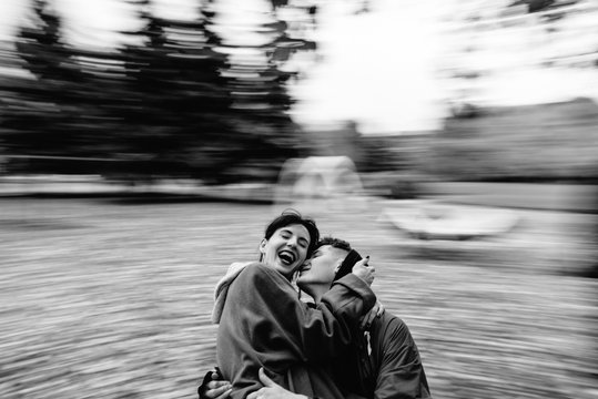 Young couple hug and kiss On The Merry-Go-Round