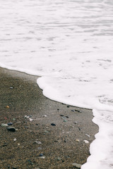 the sea wave arrives on the sandy shore . beautiful natural background