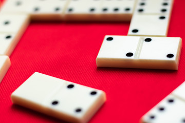  Dominoes White dominoes lie during the game on a red fabric background and a lot of space for text. Close-up