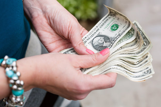 Dollar bills in women's hands