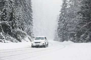 Modern car on snowy road near forest. Winter vacation