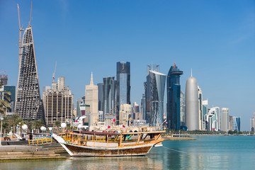 Fototapeta premium Skyscrapers in the city center with water and boat foreground of Doha, Qatar 2020.
