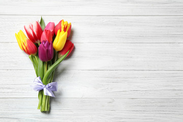 Beautiful spring tulips on white wooden table, top view. Space for text