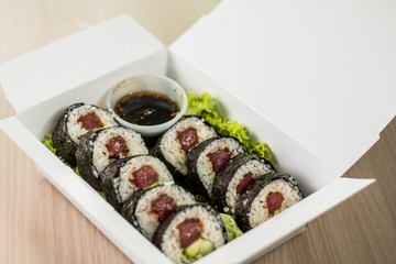 sushi con algas en caja y salsa desde arriba