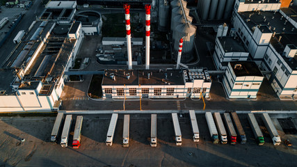 drone shot of a beer factory - tall factory pipes and a set of tanks - truck parking nearby