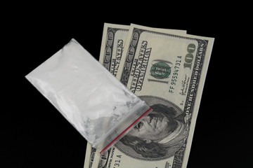 Cocaine or other illegal drugs, white powder, syringe, isolated on black glossy background