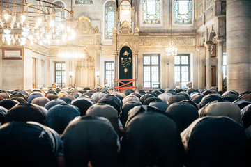 Rear view of men praying in mosque