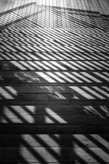 Staircase with a shadow from the railing. Close-up fragment of a staircase leading downstairs with...
