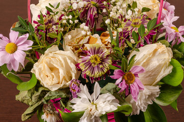 Beautiful autumn bouquet composition of dried roses and meadow flowers with leaves, floral background.