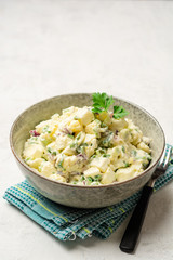 Egg salad with red onion and greens in bowl on concrete background. Selective focus.