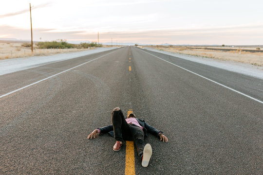 A man laying in the middle of the road