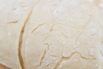 Prepared kneaded dough on a wooden table at home