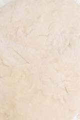 Prepared kneaded dough on a wooden table at home