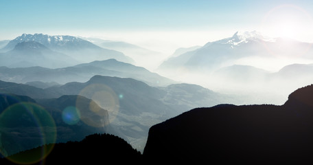 Spectacular view of mountain ranges silhouettes and fog in valleys.