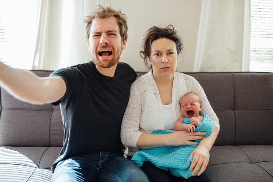 Stressed and tired new parents with screaming newborn baby