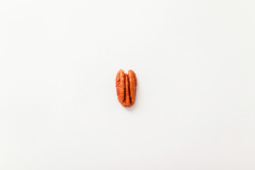 Brown pecan nut half isolated on a grey background, top view, flat style