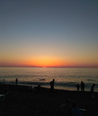 silhouette of people on beach at sunset
