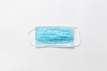 Fototapeta premium Medical mask on a gray background, view from above. Protection against germs and viruses concept