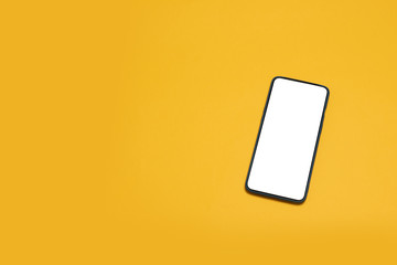 Top view mockup black smartphone on yellow background. Desktop blank smartphone
