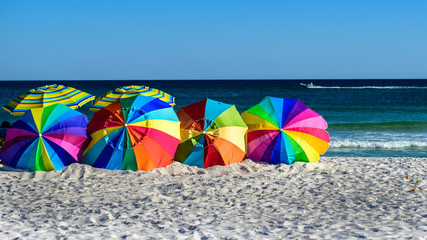 bright multi color beach umbrellas on sand