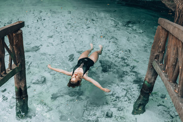 Woman floating on the water in Gran Cenote, Tulum, Mexico