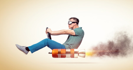 Cool man in casual clothes with goggles holds a steering wheel in his hands while driving an alternative vehicle, on yellow background.  - Powered by Adobe