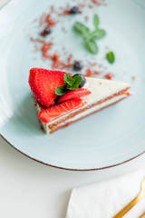 A beautiful piece of cake with berries with butter cream on a white background. Cake with red cakes.