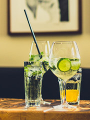 Prickelnde Cocktails im Glas mit Limetten und Eis auf Tisch in Bar