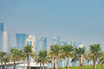 Panoramic view of modern skyline of Doha with Palms foreground. Concept of healthy environment