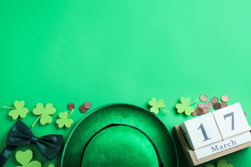 Flat lay composition with leprechaun hat on green background, space for text. St. Patrick's Day...