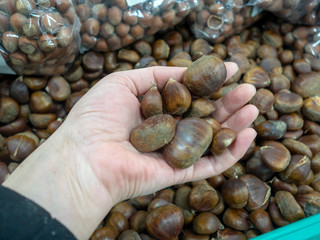 lady holding fresh organic chestnuts at the super market