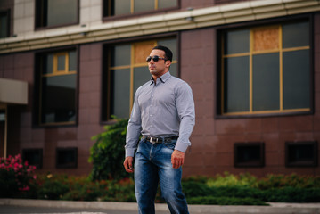 Young successful man near an office building. Business