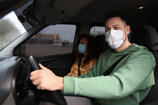 Couple with disposable masks in car. Virus protection