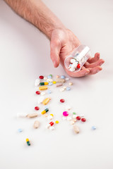 Multi-colored pills in man hand